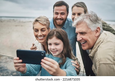 Family, selfie and girl with phone on beach for holiday, vacation or journey together by ocean. Group, mom and dad with child, grandparents and smartphone for photo in winter with smile by sea - Powered by Shutterstock