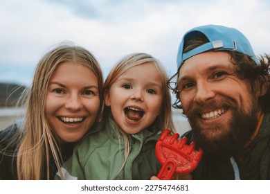 Family selfie parents with child outdoor mother and father with daughter happy smiling faces vacations lifestyle together - Powered by Shutterstock