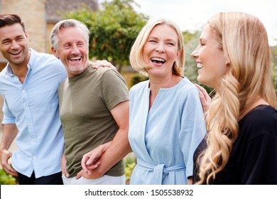 Family With Senior Parents And Adult Offspring Walking And Talking In Garden Together
