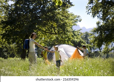 Family Setting Up Tent In Field