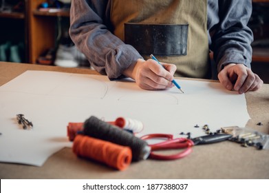 In A Family Shoe Shop A Young Apprentice Works With Paper To Create A Pattern For Shoes.