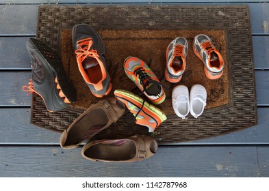 Family Shoes Of Different Sizes On The Front Door Mat