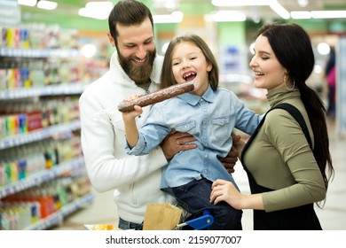 Family With Shopping Cart With Food Visiting Supermarket