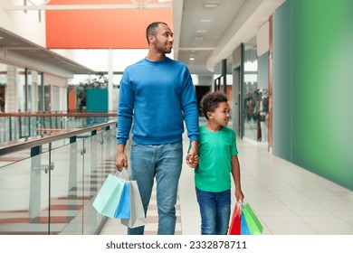 Family shopping. Happy father and son with colorful bags in mall - Powered by Shutterstock