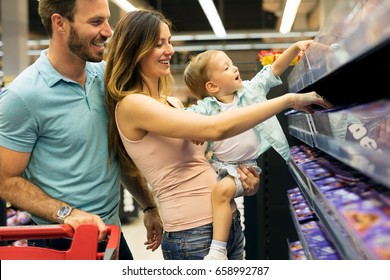 Family Shopping In Their Local Supermarket.