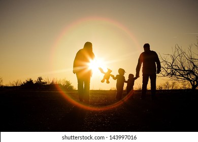 Family Silhouette With Sun Flare