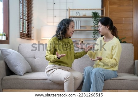Family sit on couch having dispute, grown up daughter proves her right aggressively argue with elderly mother, 60s mom in despair due to misunderstanding. Generational gap, conflicts at home concept