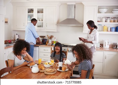 Family Sitting Around Breakfast Table Using Digital Devices - Shutterstock ID 715770085