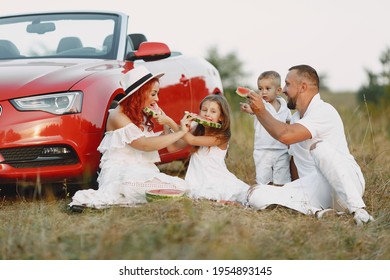 Family Sitting By The Red Cabriolet