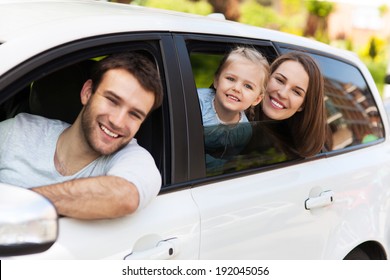 Family sitting in the car looking out windows 