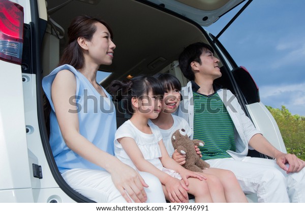 Family sitting in car\
trunk