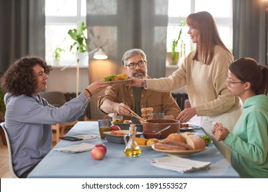 Family Sitting At Dinner Table They Are Going To Have Dinner In The Dining Room At Home