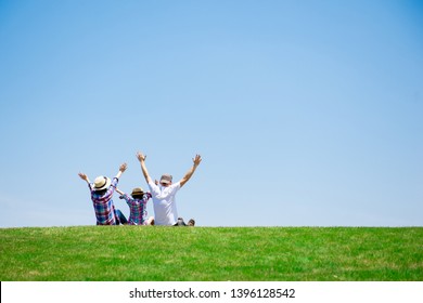Family Sitting In The Meadow
