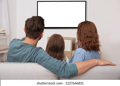 Family Sitting On Couch And Watching TV At Home, Space For Design On Screen. Leisure And Entertainment