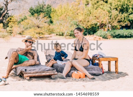 Family sitting on deck chairs at beach - Cirali, Antalya Province, Turkey