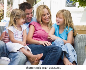 Family Sitting On Patio Smiling