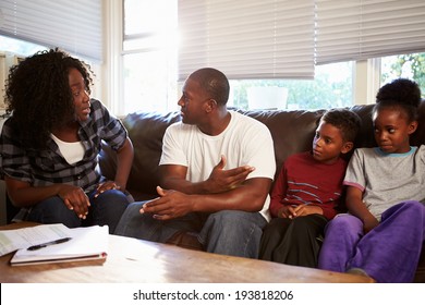 Family Sitting On Sofa With Parents Arguing