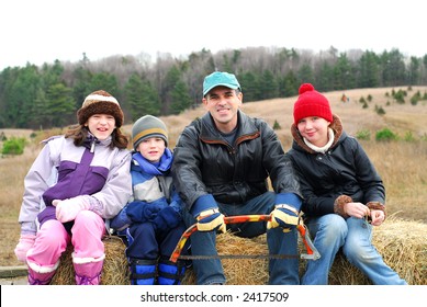 Family Sitting On A Vagon On Christmas Tree Farm