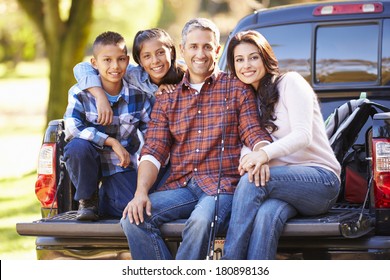 Family Sitting In Pick Up Truck On Camping Holiday