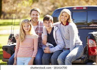 Family Sitting In Pick Up Truck On Camping Holiday