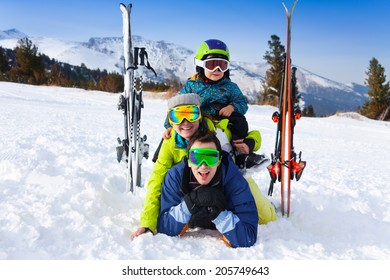 Family In Ski Masks Laying And Kid On Shoulders