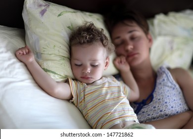 Family is sleeping on a bed at home in the morning