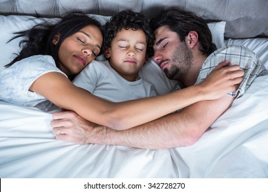 Family sleeping together in bed
