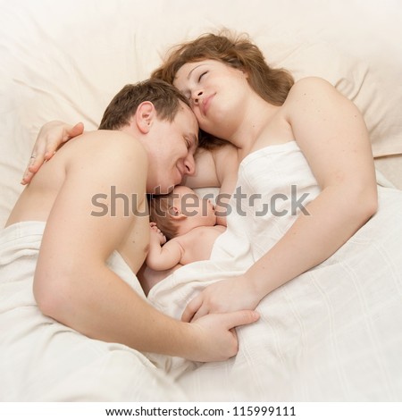 Similar – Mother reading book to her sons in the bed