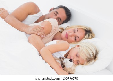 Family sleeping together on a same bed
