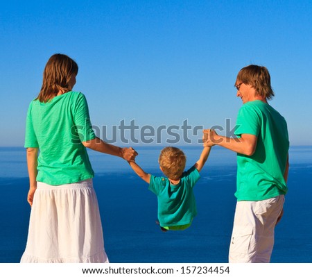 family with small child playing on the beach