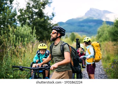 Family with small children with bicycles outdoors in summer nature, High Tatras in Slovakia.