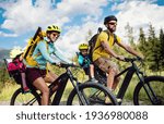 Family with small children cycling outdoors in summer nature, High Tatras in Slovakia.