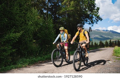 Family with small children cycling outdoors in summer nature, High Tatras in Slovakia.