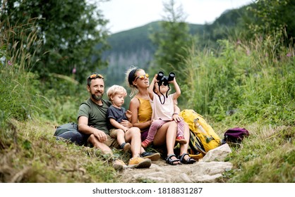 Family With Small Children Hiking Outdoors In Summer Nature, Sitting And Resting.