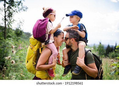 Family with small children hiking outdoors in summer nature.