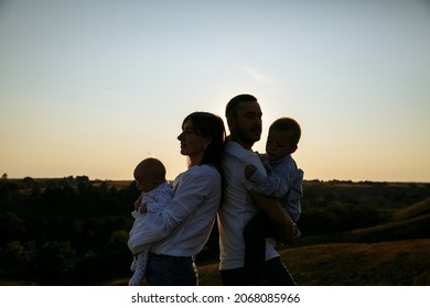 family with small children on the background of the sunset sky