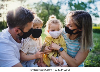 Family With Small Children Outdoors In Nature, Wearing Face Masks.