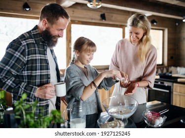 Family With Small Daughter Cooking Indoors, Winter Holiday In Private Apartment.