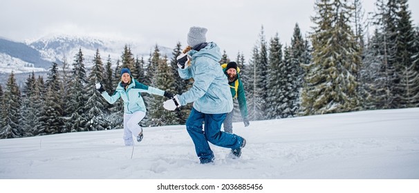 Family with small daughter having fun outdoors in winter nature, Tatra mountains Slovakia.