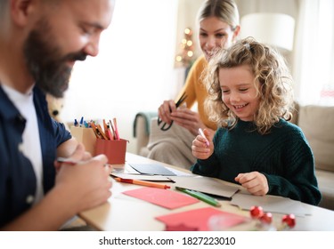 Family with small daughter indoors at home at Christmas, making Christmas cards. - Powered by Shutterstock