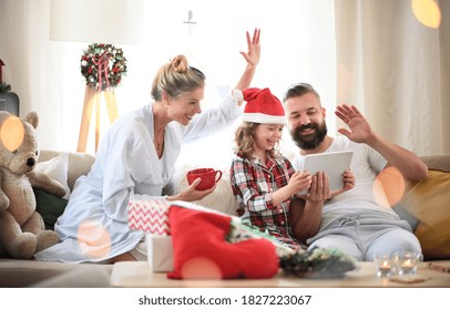 Family With Small Daughter Indoors At Home At Christmas, Having Video Call.