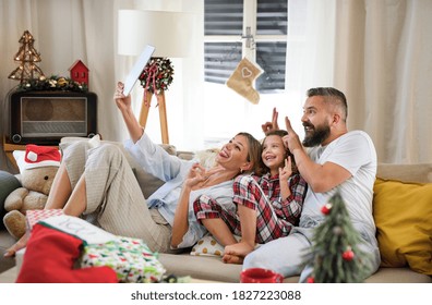 Family With Small Daughter Indoors At Home At Christmas, Having Video Call.