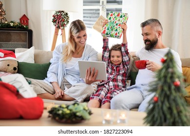 Family with small daughter indoors at home at Christmas, having video call. - Powered by Shutterstock