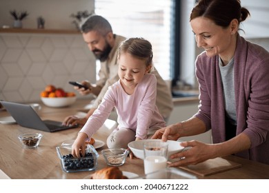 Family with small daughter indoors in kitchen at home, everyday life and home office with child concept. - Shutterstock ID 2040671222