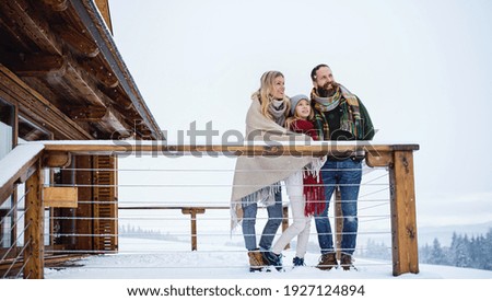 Family with small daughter on terrace outdoors, holiday in winter nature.