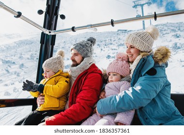 Family With Small Son And Daughter Inside A Cable Car Cabin, Holiday In Snowy Winter Nature.