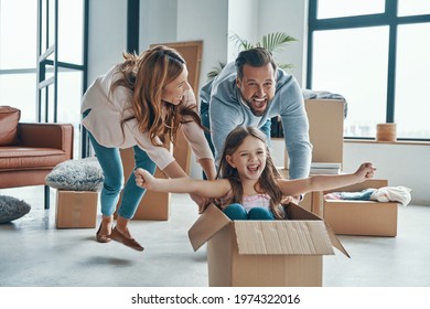 Family Smiling And Unboxing Their Stuff While Moving Into A New Apartment