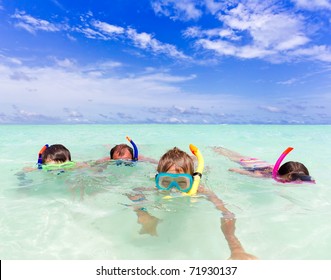 	A Family Snorkeling In The Ocean.