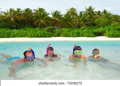 	A Family Snorkeling In The Water Together.