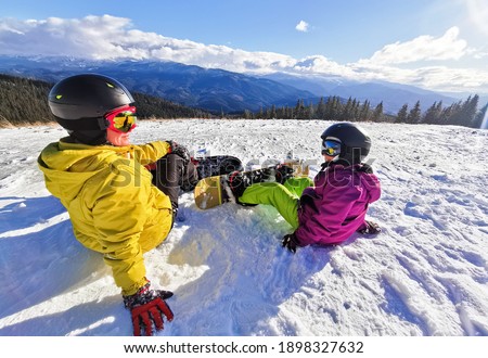 family of snowboarders at winter resort in the mountains